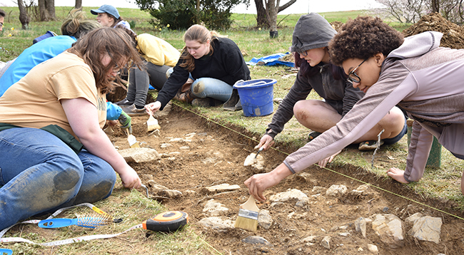 Photo of Hollins students digging in a historical site.